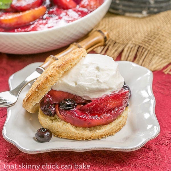 Side view of a Blueberry Peach Shortcake topped with whipped cream on a dessert plate