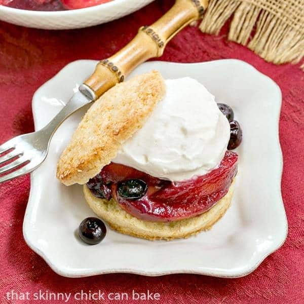 Overhead view of a Blueberry Peach Shortcakes on a square white plate with a bamboo fork