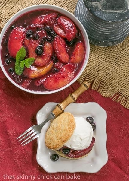 Overhead view of Blueberry Peach Shortcakes with a bowl of macerated peaches and blueberries