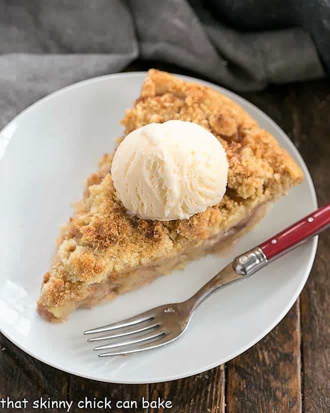 Dutch Apple Pie slice on a white plate with a red handled fork.