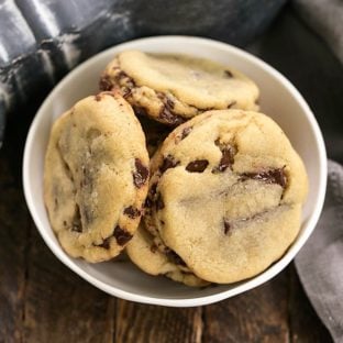 Overhead view of layered chocolate chip cookies in a white bowl