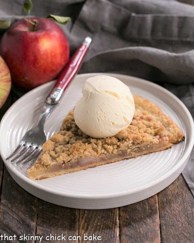 Apple Pie Pizza slice with a scoop of ice cream on a white dessert plate.