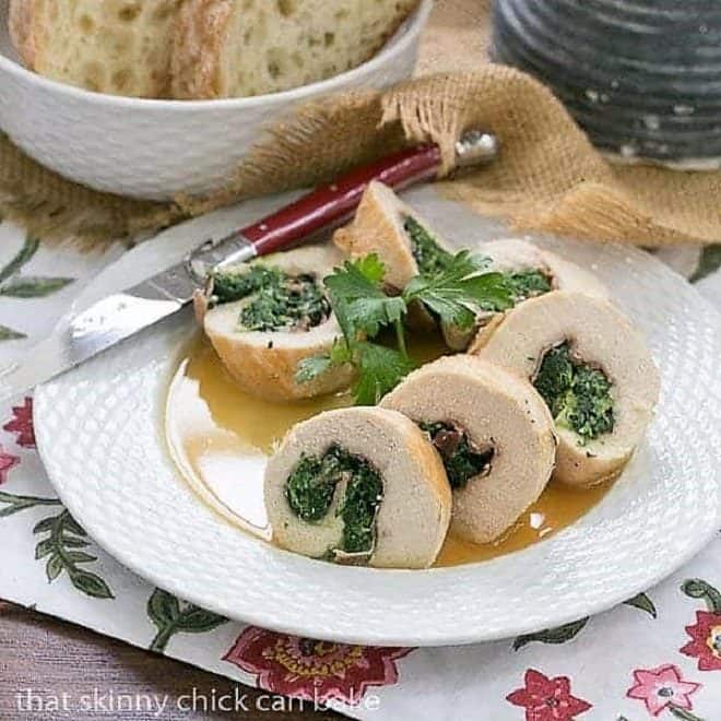 Chicken Saltimbocca Pinwheels on a white ceramic basket weave plate with a red knife