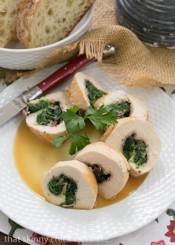 Chicken Spinach and Prosciutto Pinwheels arranged on a white plate