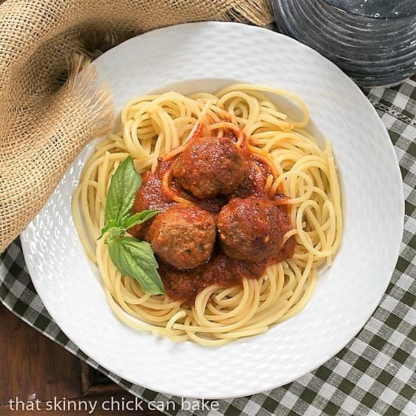 Overhead view of Classic Italian Meat Sauce over pasta and meatballs in a white bowl.