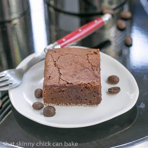 Fudgy Mocha Brownies on a white plate with coffee beans.