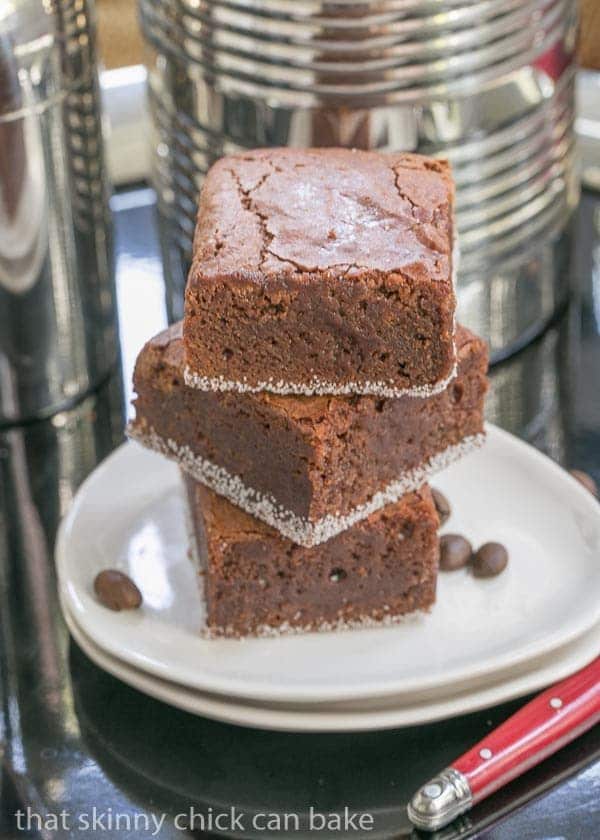 3 Fudgy Mocha Brownies stacked on two oval white plates.