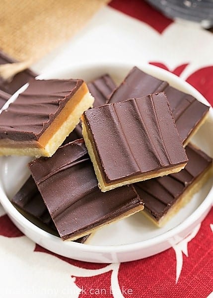 Ganache Topped Caramel Bars on a rimmed white plate.