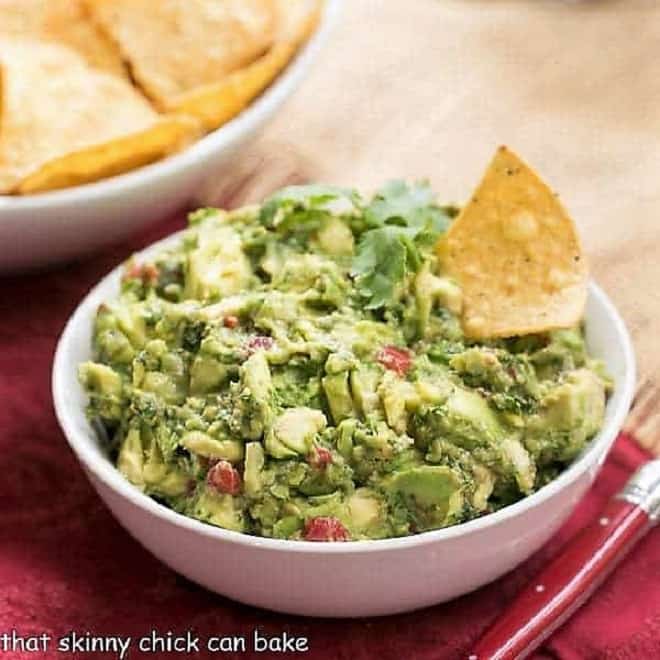 Mary's Classic Guacamole in a white ceramic bowl with a red handled serving spoon