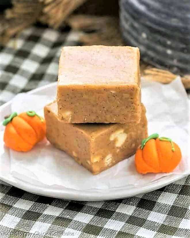 Easy Pumpkin Fudge stacked on a white plate with candy pumpkins