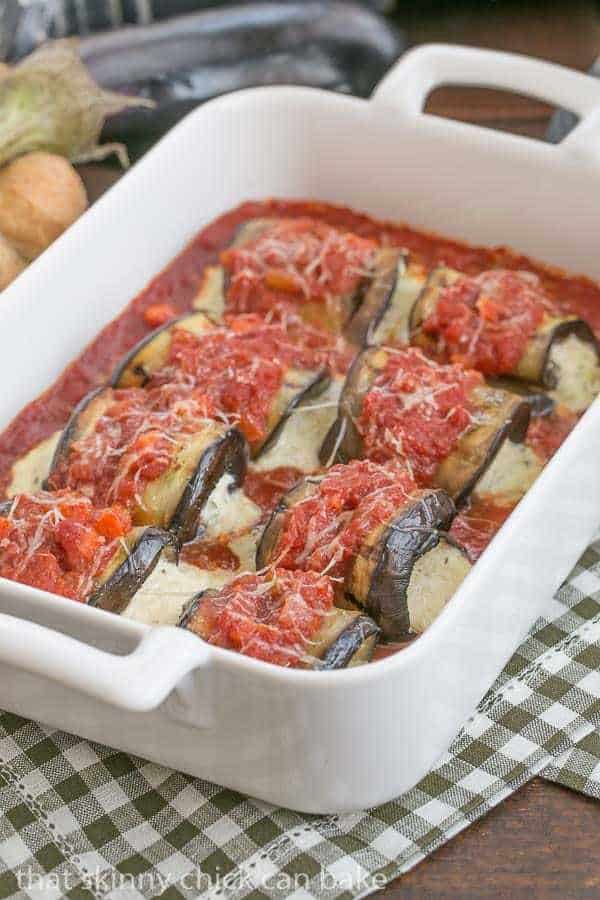 Eggplant Rollatini with Ricotta and Mozzarella lined up in a white casserole dish