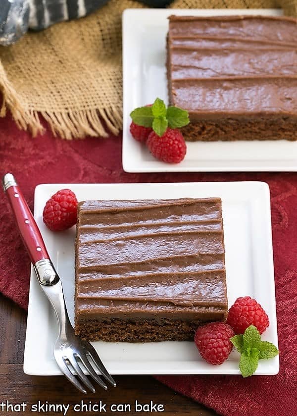 Chocolate Sheet Cake slices on a square white plates with raspberries