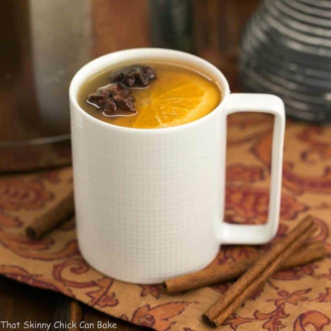 Mulled Apple Cider - Hot cider flavored with vanilla, oranges and warm autumn spices. Perfect for holiday parties, apres ski parties or anytime you need to warm your soul Mulled Apple Cider in a white mug