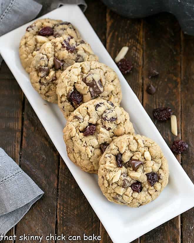 Overhead view of a white tray of easy oatmeal cookies loaded with chocolate, dried cherries and nuts.