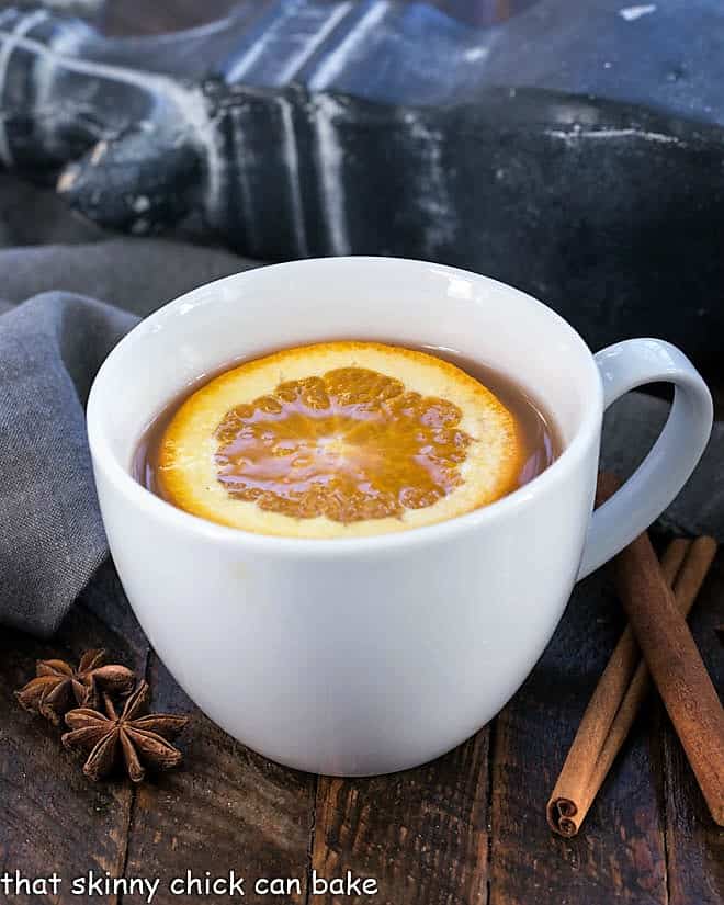 Mulled Apple Cider topped with an orange slice in a round mug.