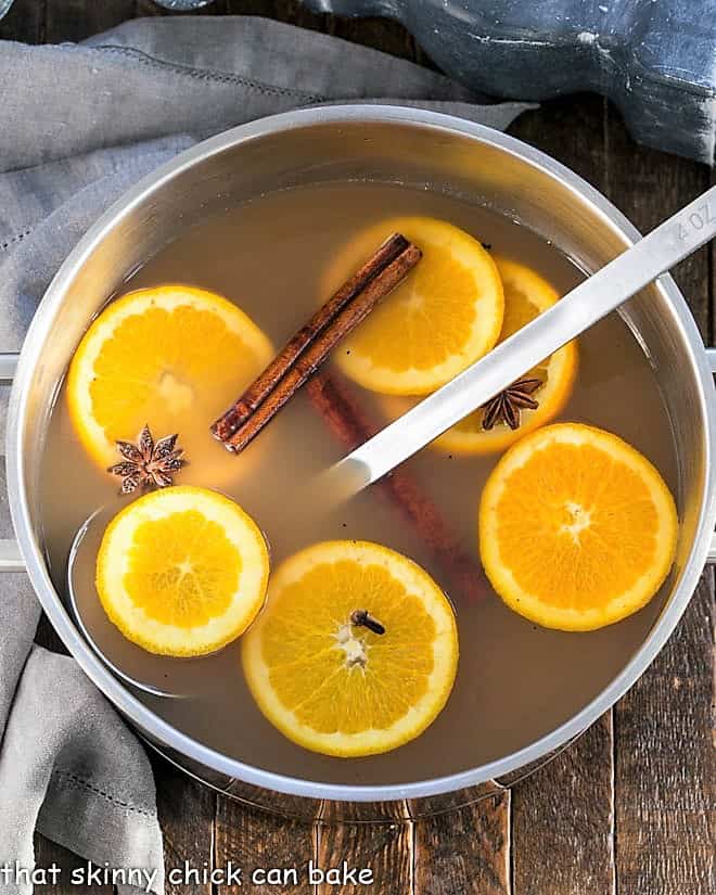 Hot Apple Cider Recipe - Hot cider flavored with vanilla, oranges and warm autumn spices. Perfect for holiday parties, apres ski parties or anytime you need to warm your soul Mulled Apple Cider in a stock pot with orange slices and spices.