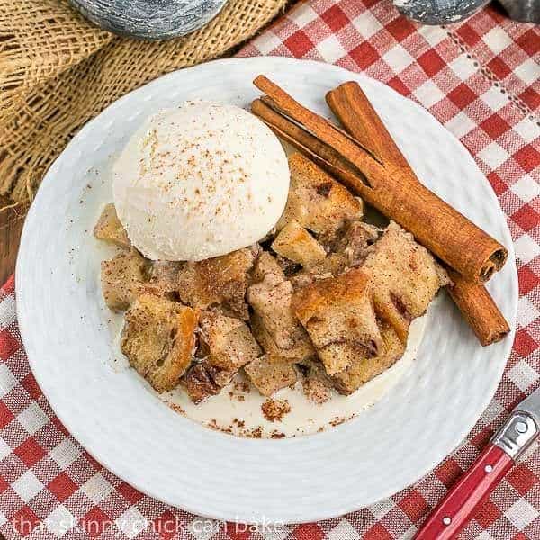 Slow Cooker Apple Pecan Bread Pudding on a round white plate on a red/white checked napkin