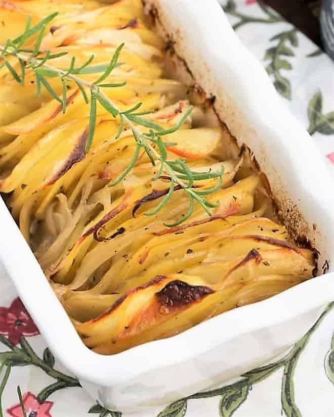 hasseback potato casserole with a sprig of rosemary