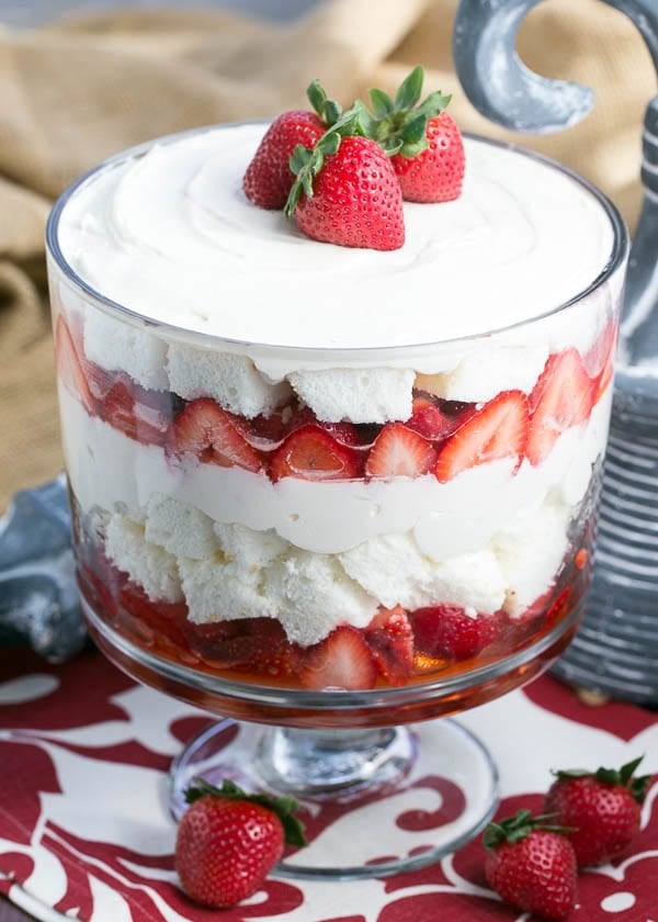 A close up strawberry cheesecake trifle topped with 3 strawberries