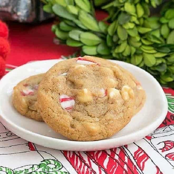 3 White Chocolate Candy Cane Cookies on a white plate over a holiday napkin.