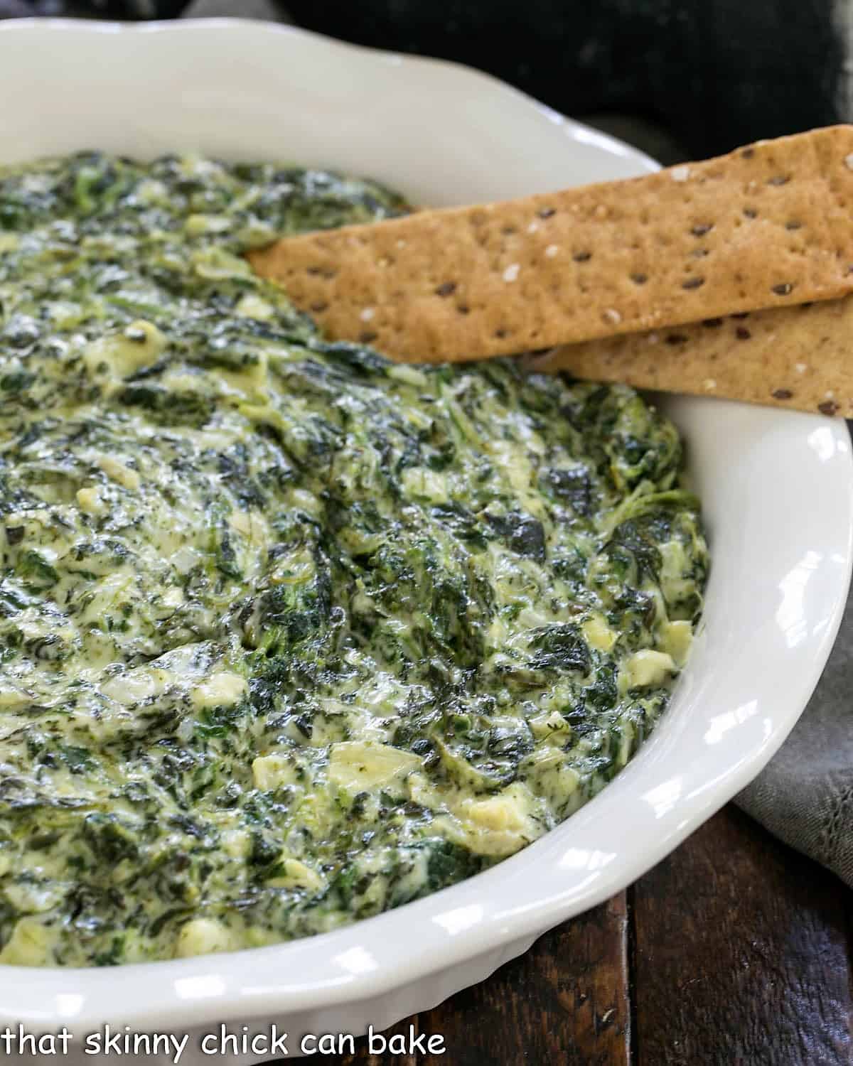 Baked Cheesy Spinach Dip in a white ceramic dish.