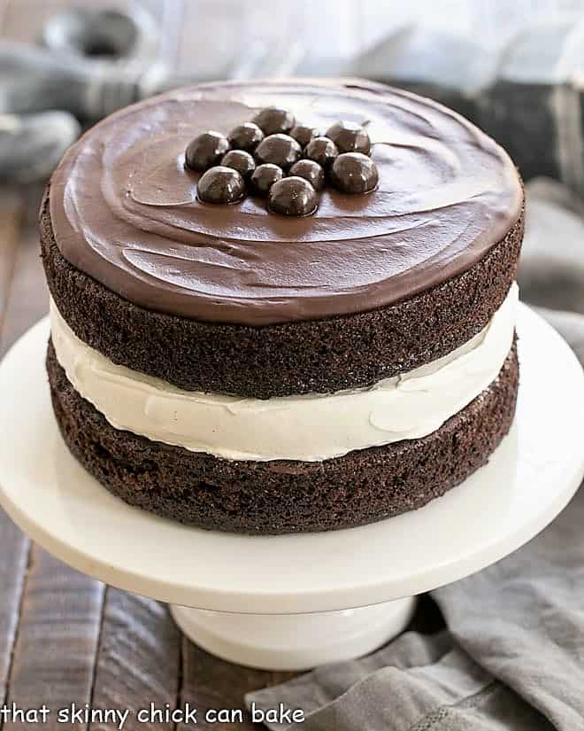 Ding Dong Cake - a cake designed to look like a Hostess Ding Dong on a white cake stand.