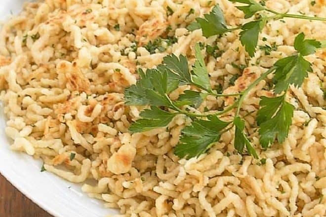 Spaetzel topped with parsley sprig on a white platter