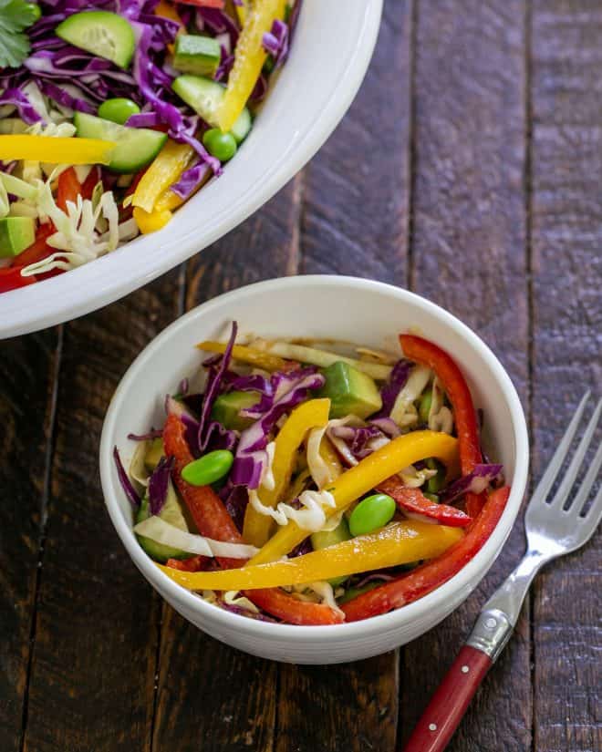 Overhead view of small bowl of Thai salad next to the serving bowl