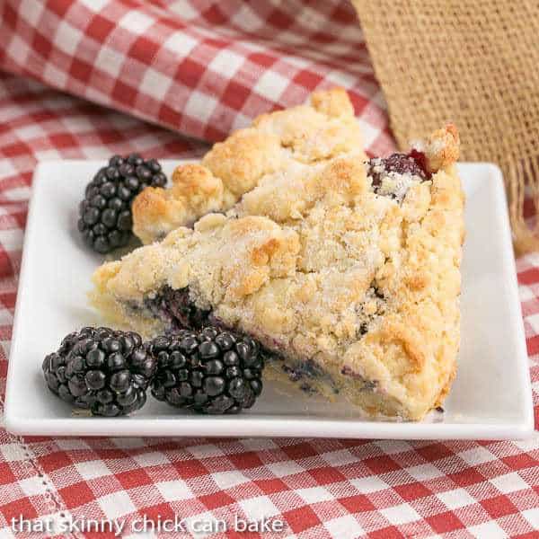 Fresh Blackberry Scones with Cream on a white square plate.