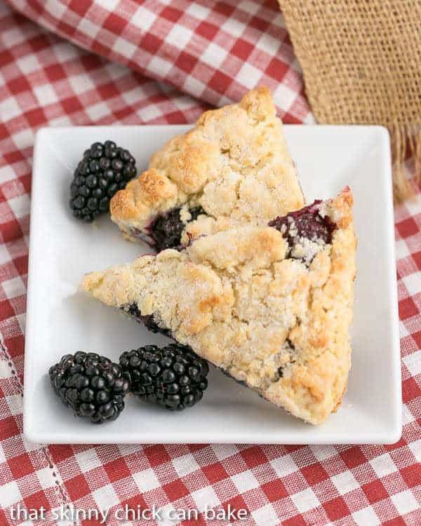 Overhead view of 2 of the best scones recipe with blackberries on a white plate.