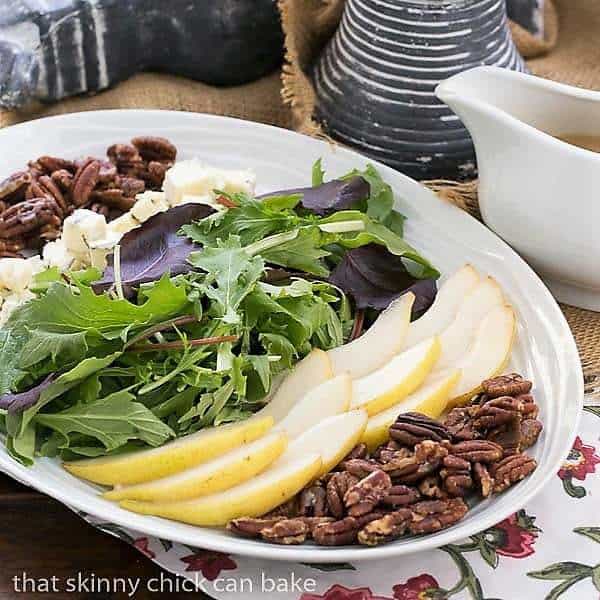 Blue Cheese and Pear Salad composed in layers on a white, oval platter.