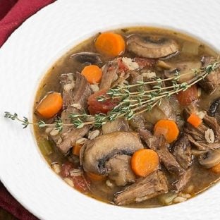 Overhead view of vegetable beef soup in a white bowl