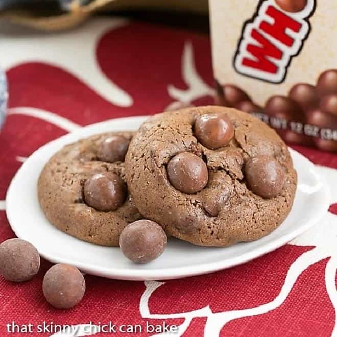 2 Whopper Cookies  on a small white plate on a red and white napkin with a few Whoppers