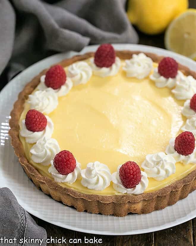 Close view of Creamy Lemon Tart on a white serving dish.