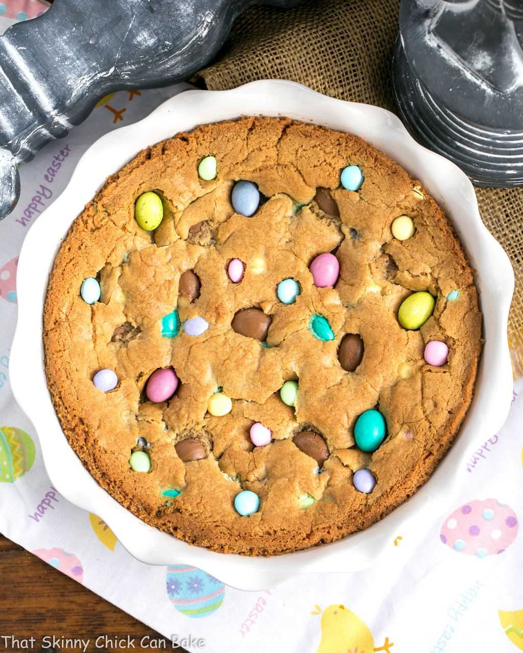 overhead image of a large cookie cake studded with various types of Easter candy.