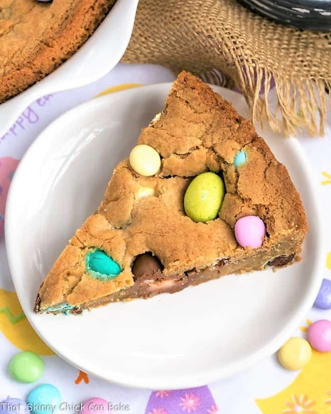 Slice of Easter cookie cake on a white dessert plate.