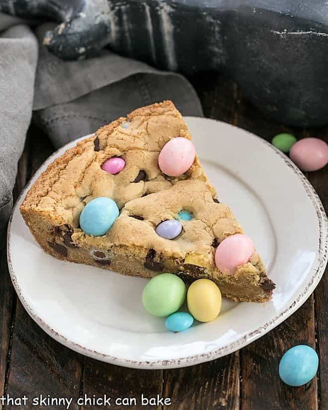 Slice of Easter cookie cake on a white dessert plate