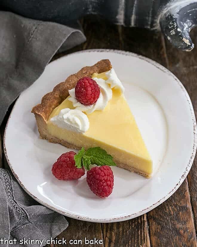 Slice of Creamy Lemon Tart on a white dessert plate.