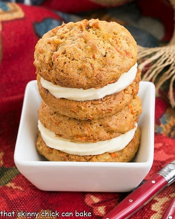 2 Carrot Cake Whoopie Pies stacked in a white bowl.