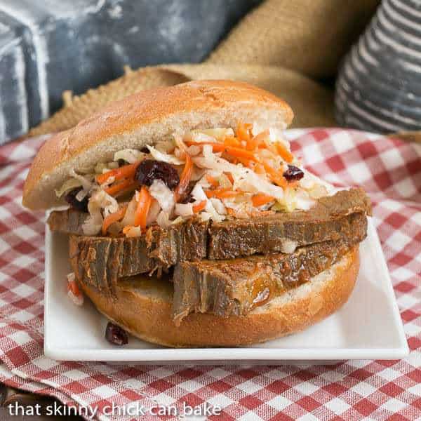 Oven Braised Texas Brisket on a large kaiser bun, topped with coleslaw