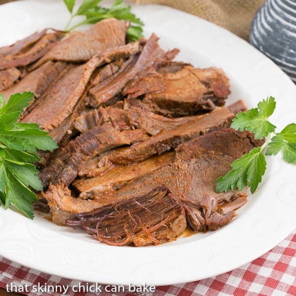 slices of Oven Braised Texas Brisket on a white serving platter