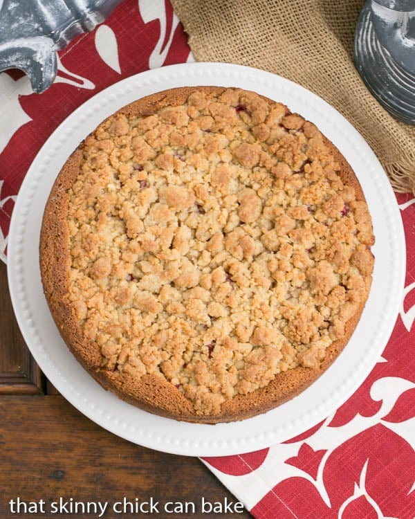 Overhead view of raspberry coffee cake on a white serving plate