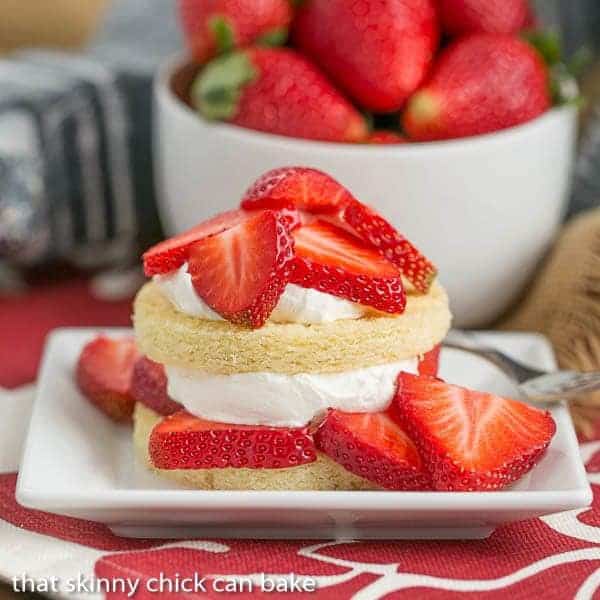 a plate of Strawberry Shortcake made with slices of Olive Oil Cake, fresh strawberry slices and whipped cream