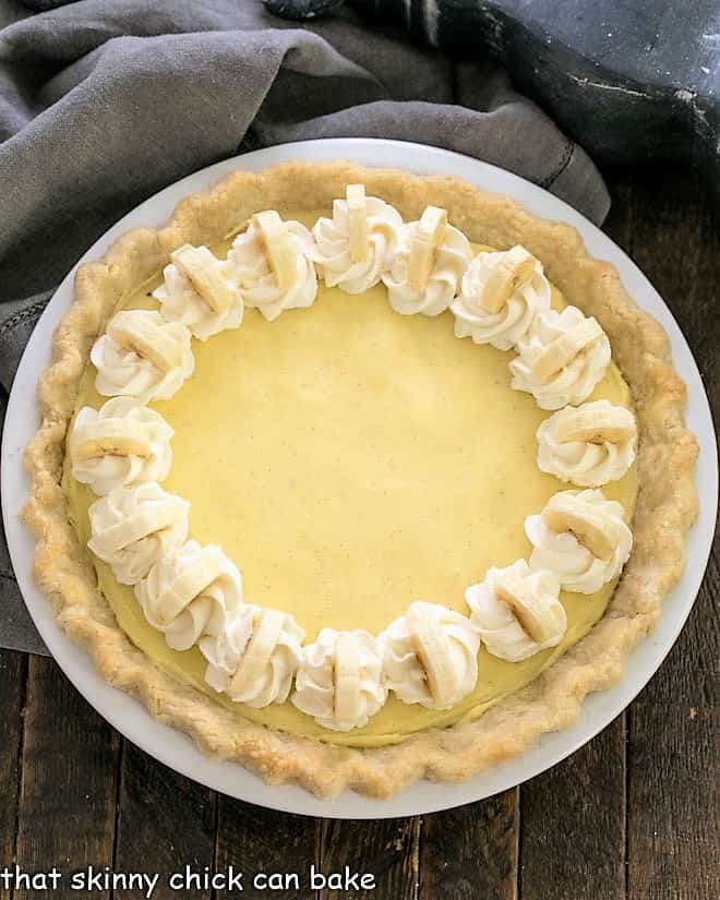 Overhead view of banana cream pie with whipped cream and banana slices to garnish.