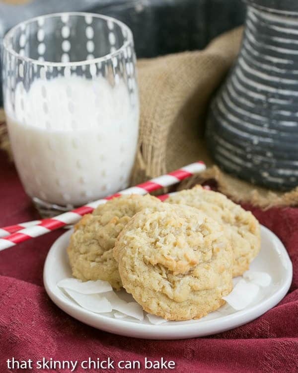 Chewy Coconut Cookies - Buttery cookies chock full of coconut! Chewy Coconut Cookies on a plate with a glass of milk