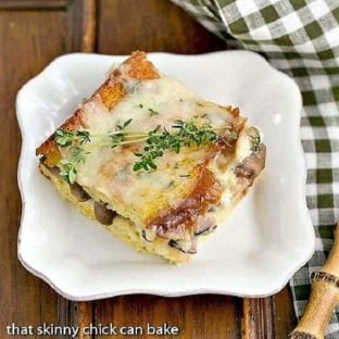 A slice of Ham and Mushroom Strata on a square white plate