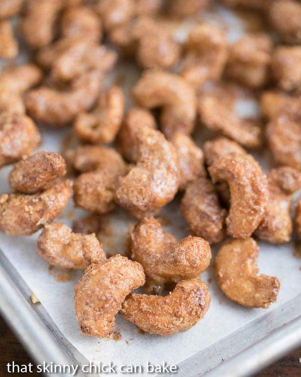 Spicy Sugared Cashews on a parchment lined baking sheet.