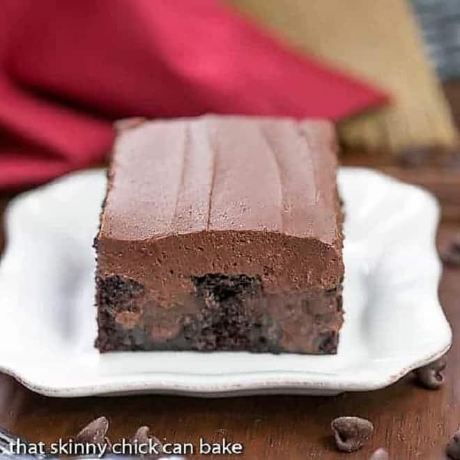 A slice of Triple Chocolate Poke Cake on a square white plate