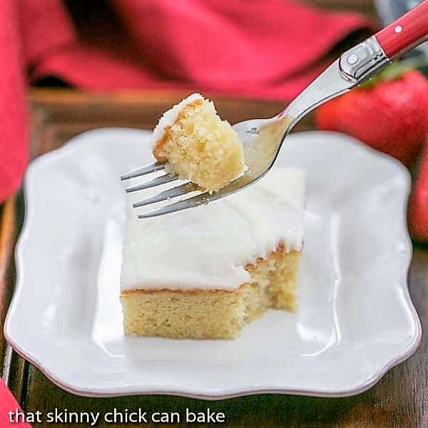 White sheet cake slice with a forkful removed.