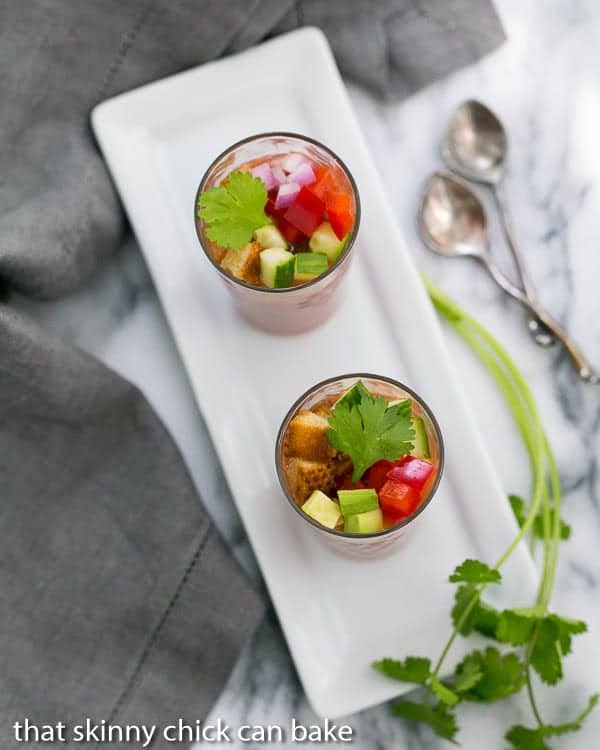Gazpacho Shooters on a white rectangular tray with a sprig of cilantro